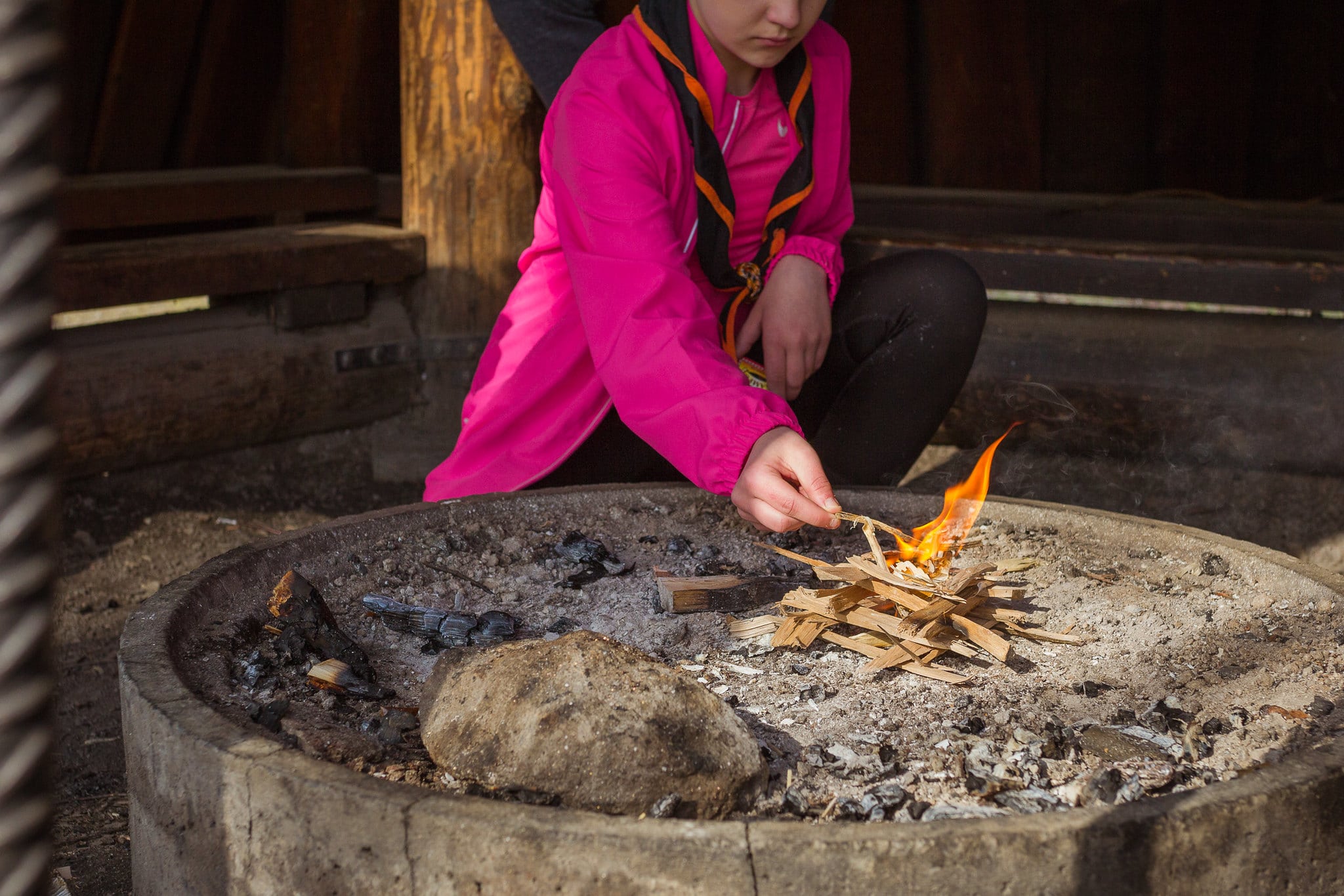 Nuori sytyttämässä nuotiota.