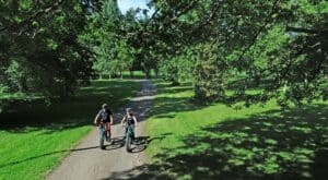Suunta luontoon hanke kaksi pyöräilijää puistomaisemassa Kalvolan kirkkopolulla