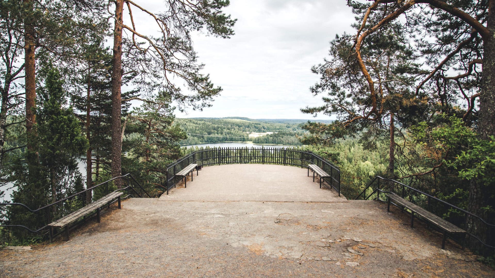 Maisema avautuu metsän ympäröimään järveen näköalatasanteelta.