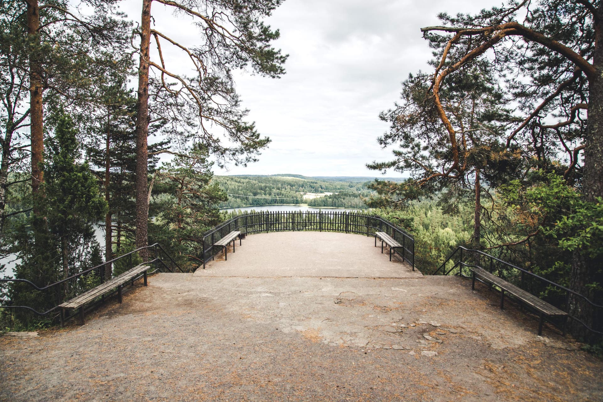 Maisema avautuu metsän ympäröimään järveen näköalatasanteelta.