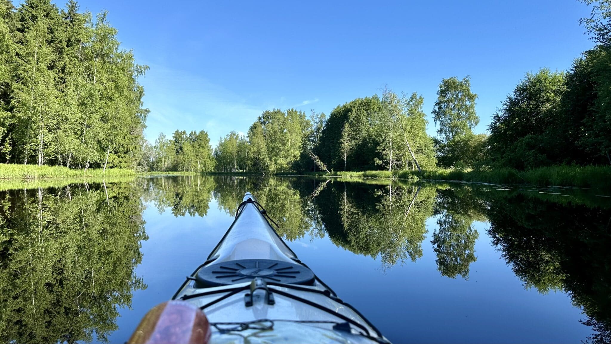 Canoe is paddling in a still river.