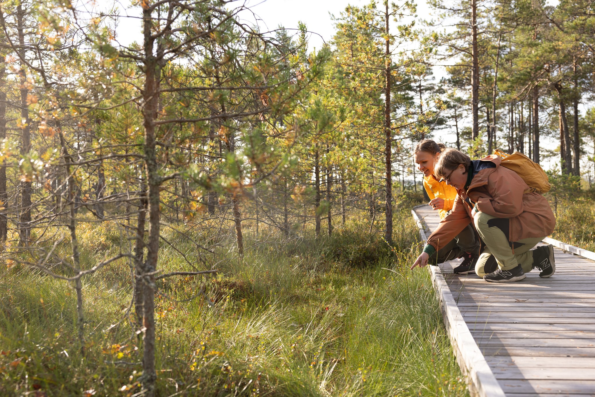 Two women exploring nature from their knees