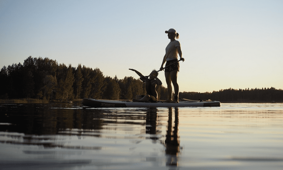 Nainen ja poika ovat sup-laudalla.