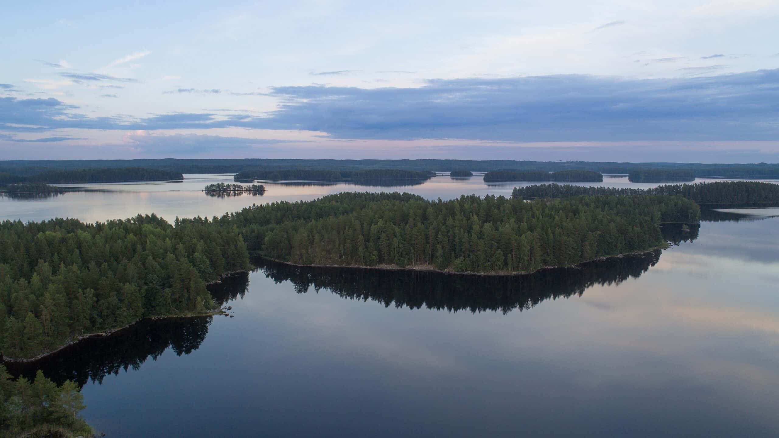 Järvimaisema ilta-aikaan kuvattuna, keskellä suuri saari ja taaempana pienempiä saaria.