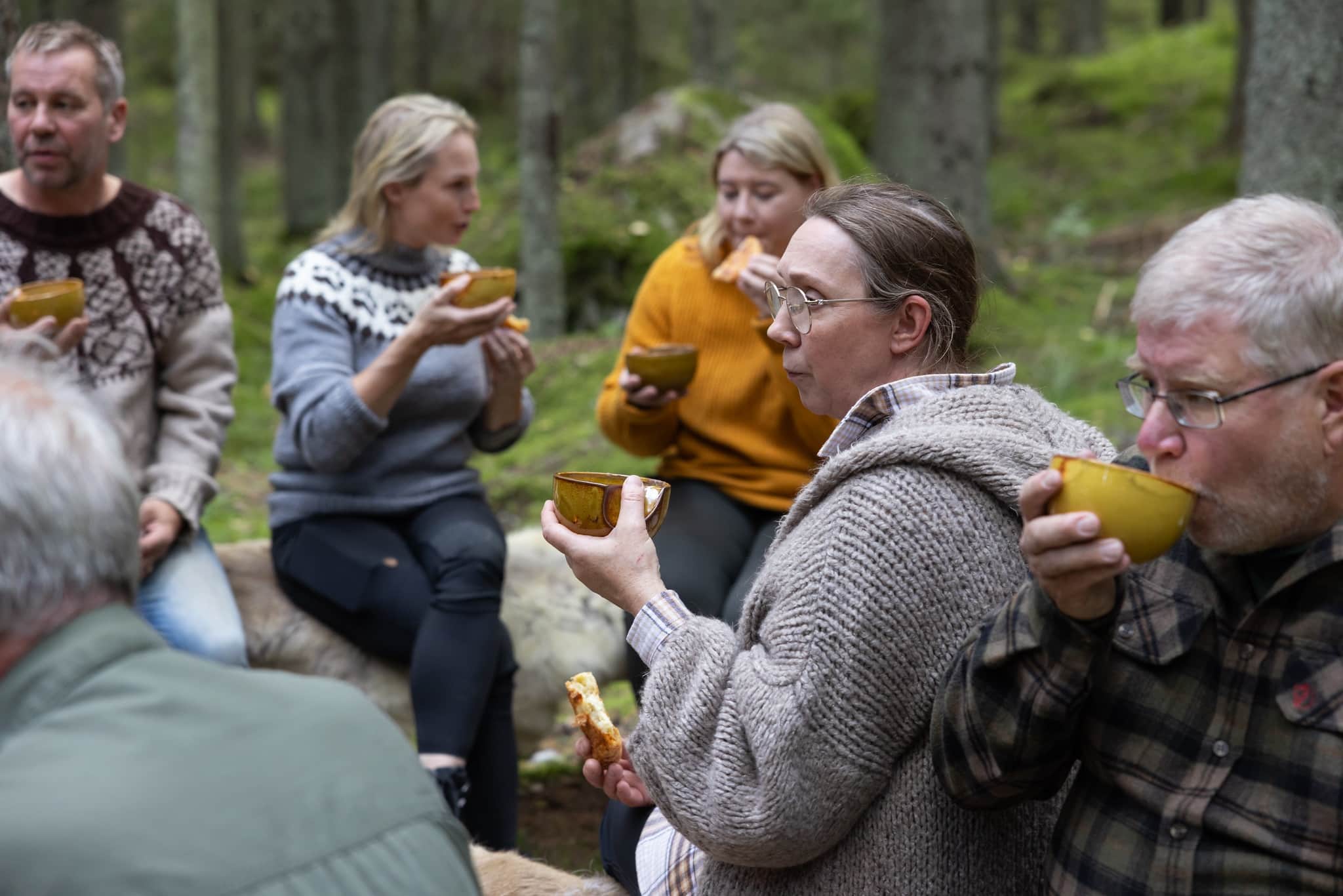 Group of people enjoying meal at forest.