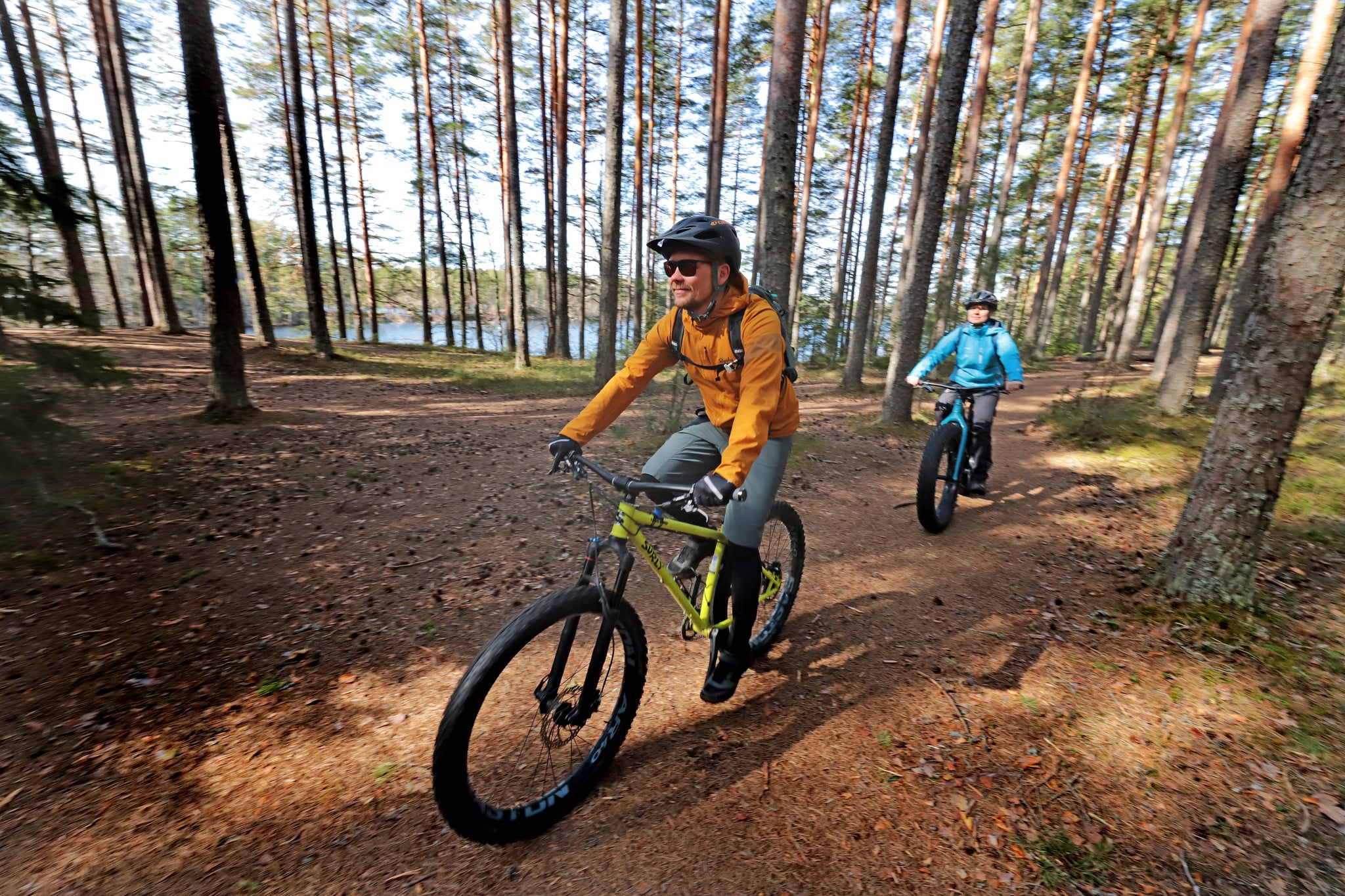 Kaksi maastopyöräilijää metsässä.