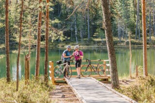 Two women are looking at a map. They are cycling.