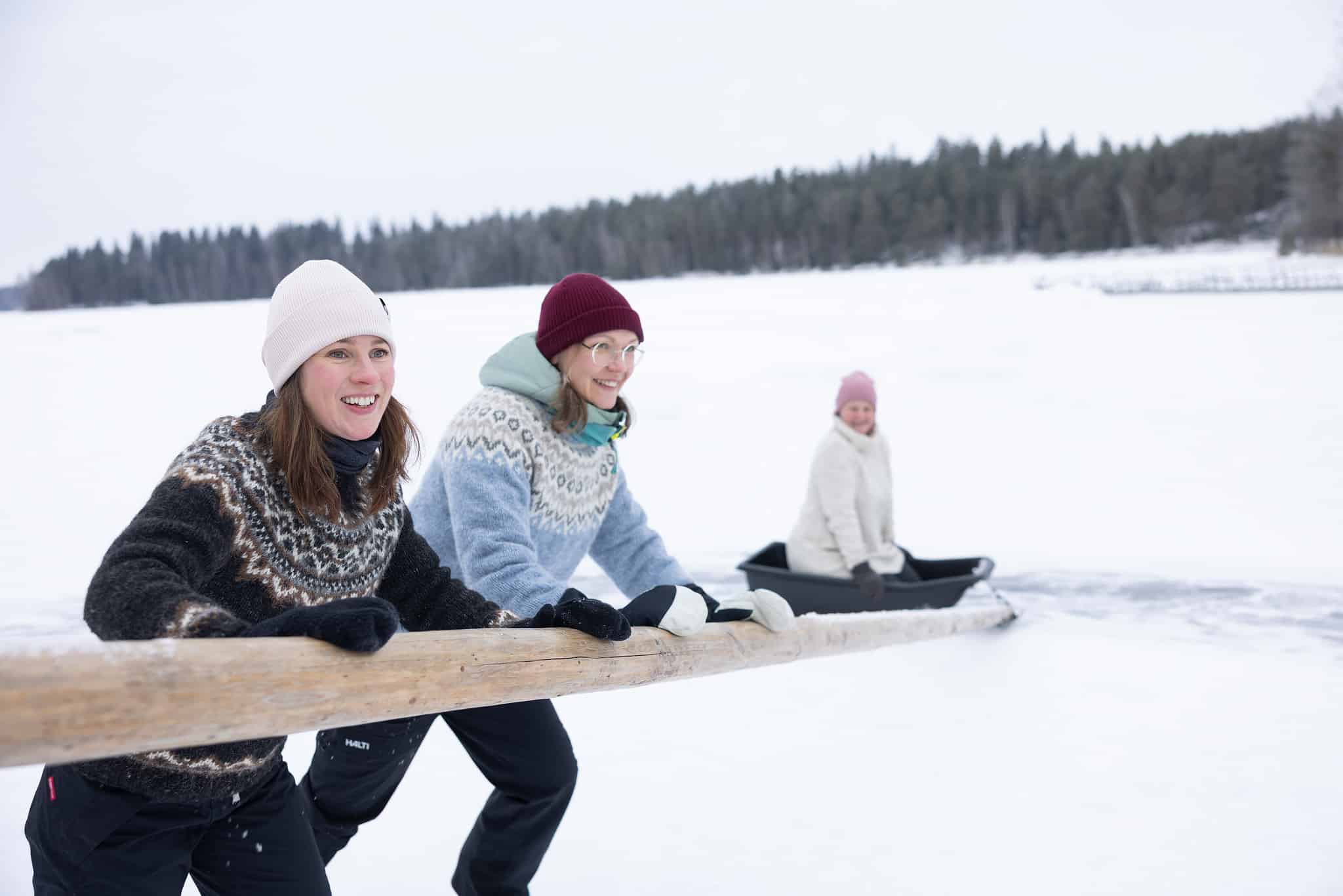 Two women are pushing a sled in winter Häme.